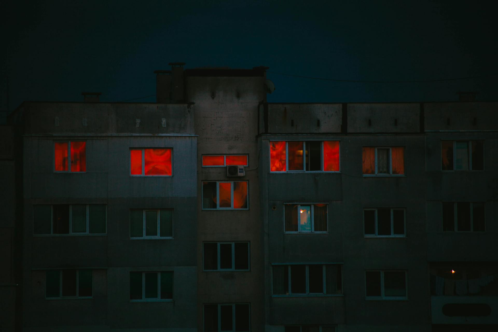 Red Lights on the Windows of an Apartment Building