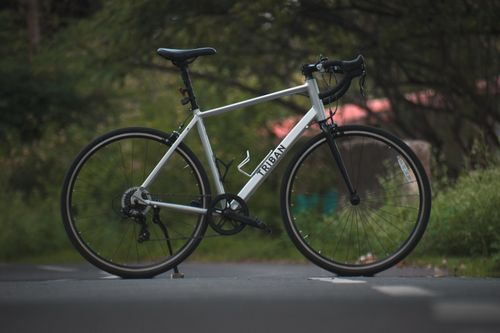 Free A Triban road bicycle parked on an empty outdoor path with greenery around. Stock Photo