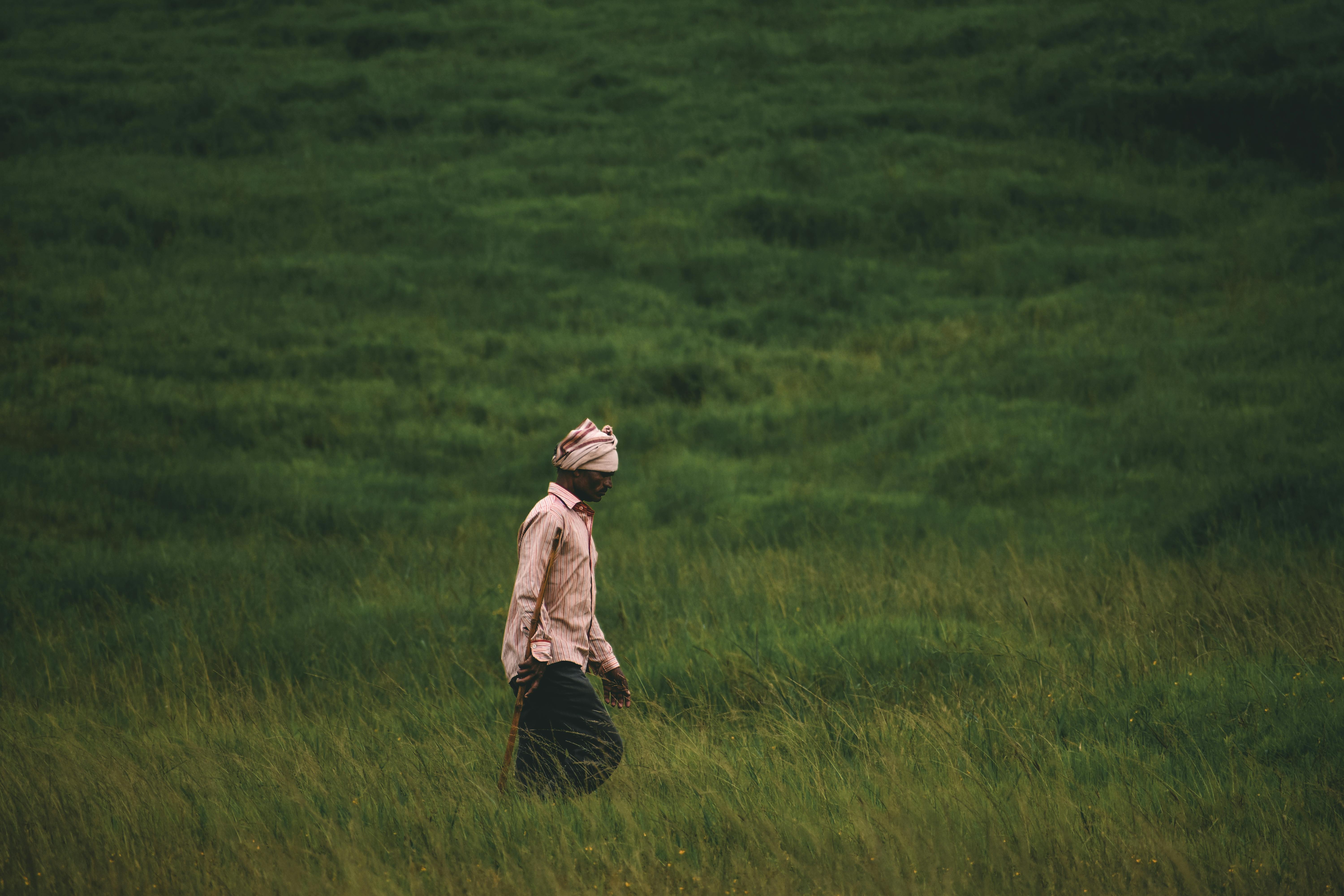 photo-of-a-man-standing-into-meadow-with-black-shorts-and-white-jacket