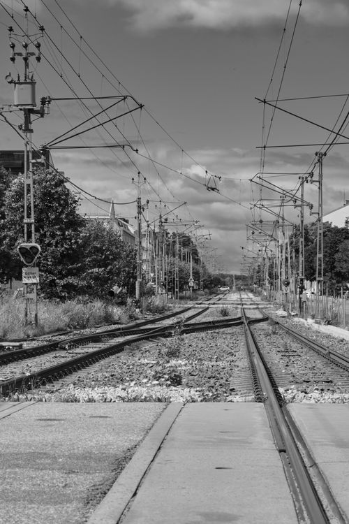 Free Monochrome view down railroad tracks in city setting, showcasing infrastructure. Stock Photo