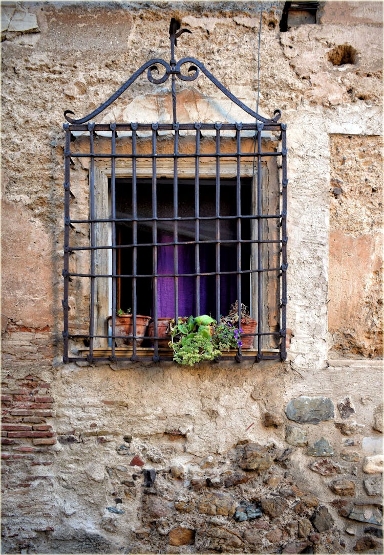 A Window With A Wrought Iron Grille