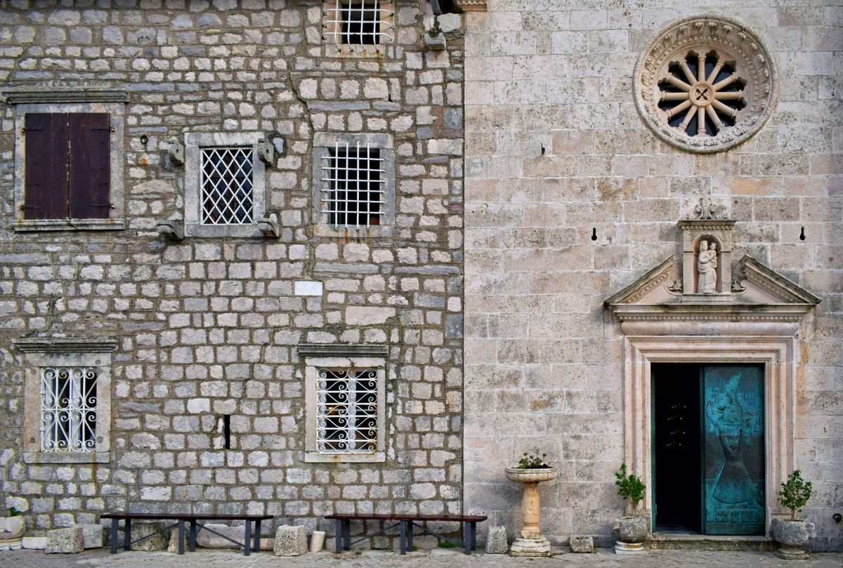 The vintage stone wall of a church in Montenegro — the baroque heritage of the Bay of Kotor