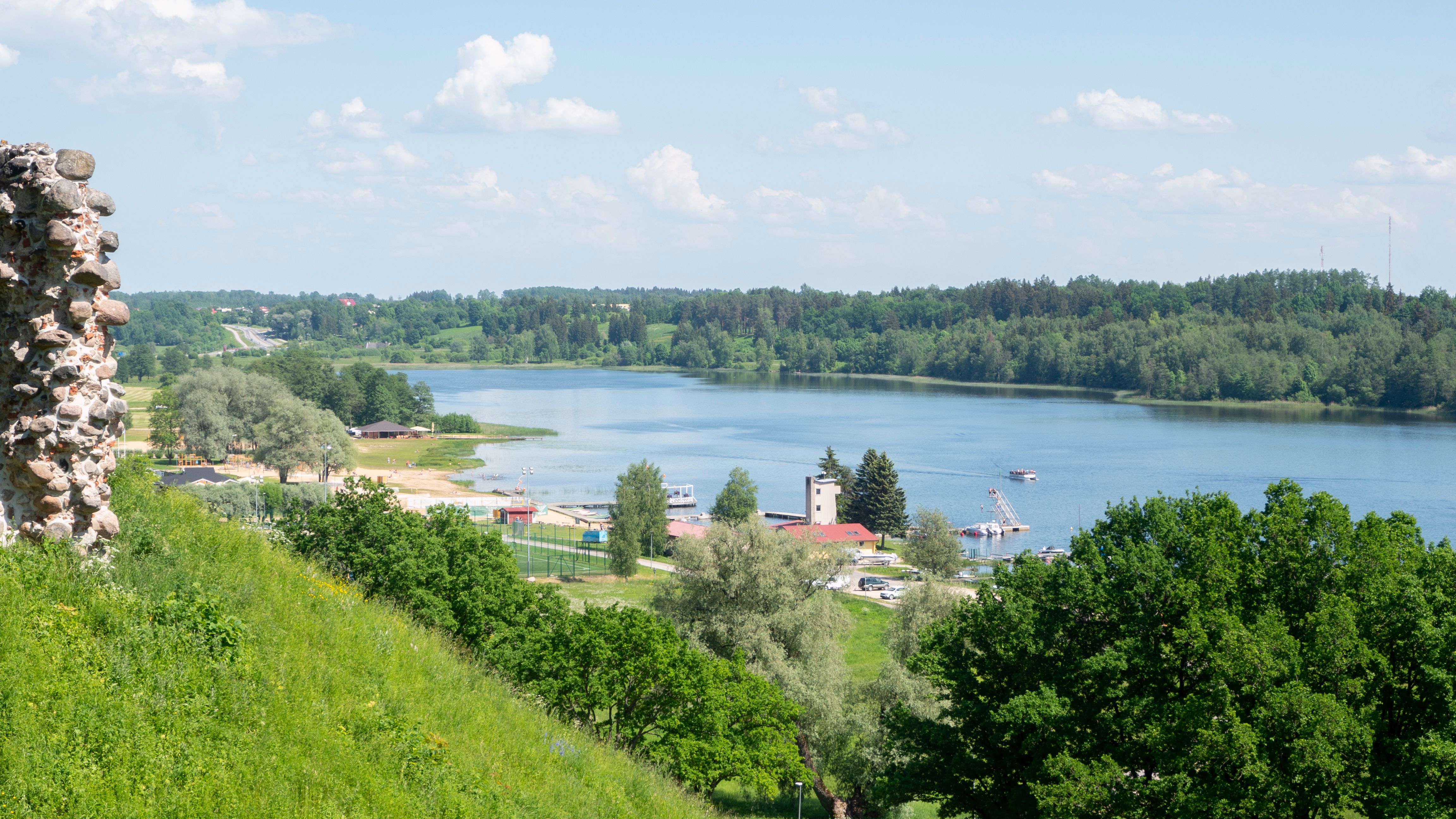 Wooden houses above Viljandi lake with the suspension bridge and castle hills