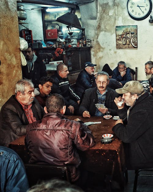 A Group of Men Sitting on the Chair while Gambling