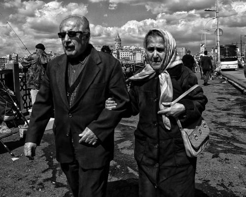 Free Black and white photo of an elderly couple walking in Istanbul, showcasing city life. Stock Photo