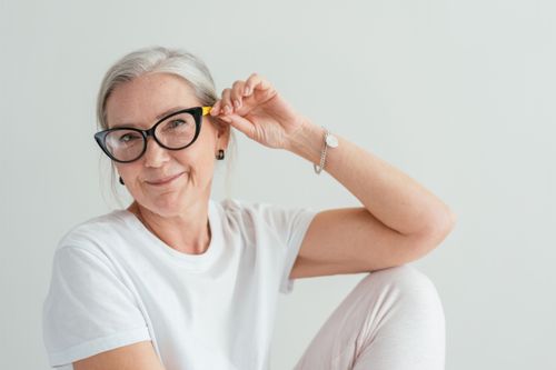 Free A happy senior woman wearing stylish eyeglasses poses indoors with a warm smile. Stock Photo