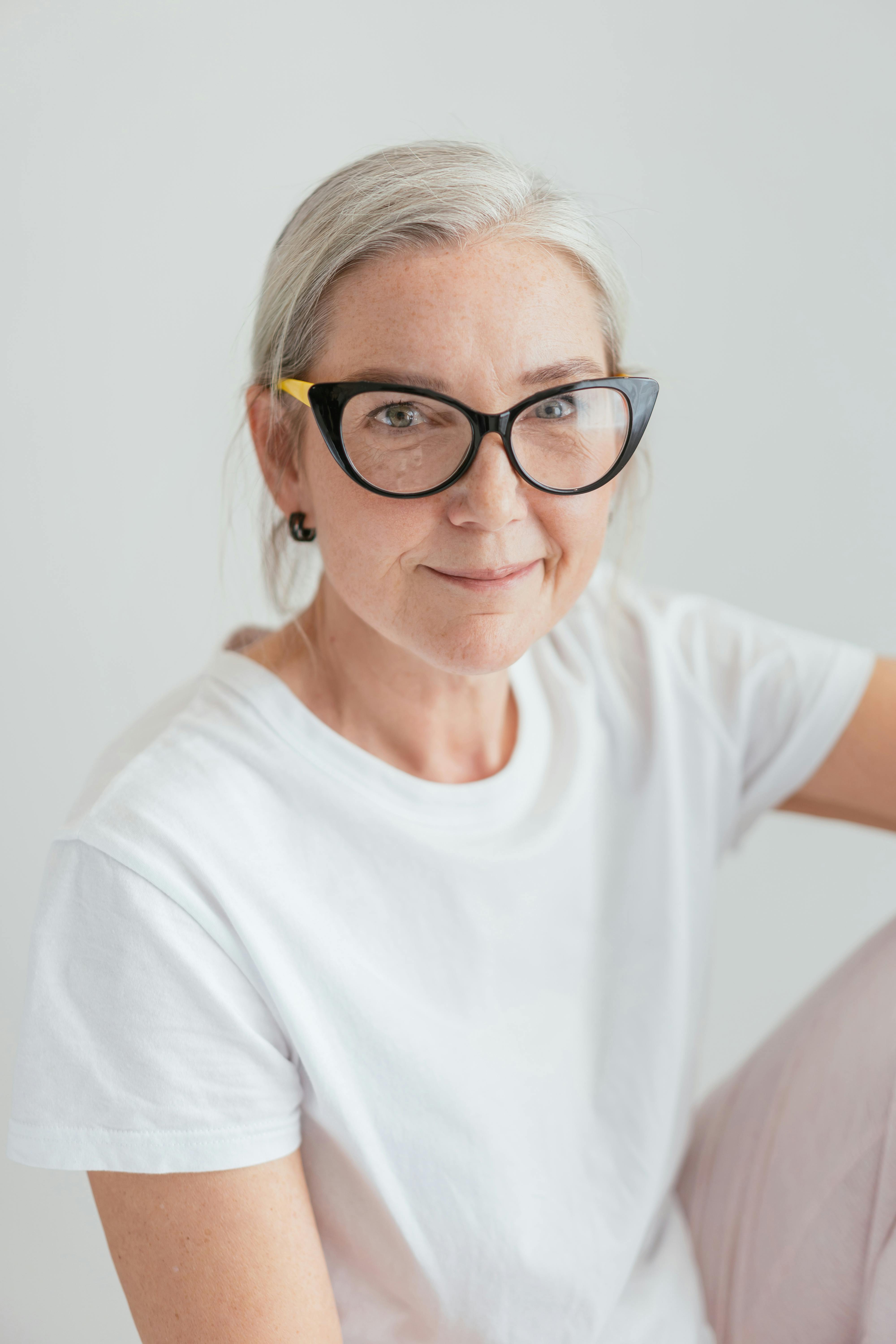 an elderly woman in white shirt wearing eyeglasses