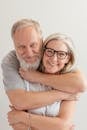 Close-Up Shot of a Happy Elderly Couple Hugging while Looking at Camera