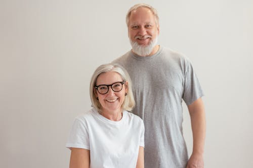 Cheerful senior couple smiling indoors, capturing a warm and happy moment together.