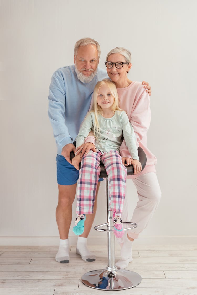 An Elderly Couple Smiling Together With Their Grandchild