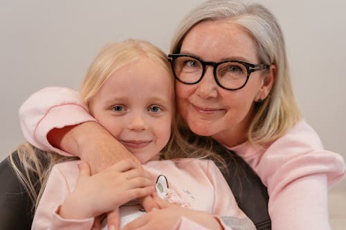 Free An Elderly Woman Embracing Her Grandchild Stock Photo