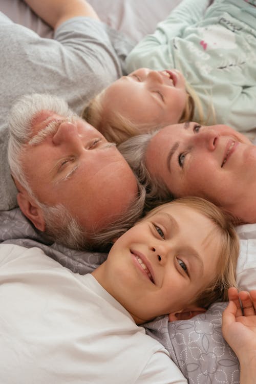 Free Family Lying on Bed Together Stock Photo