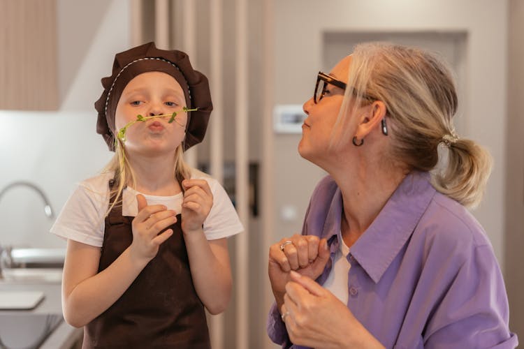 Grandmother And Granddaughter Playing In The Kitchen