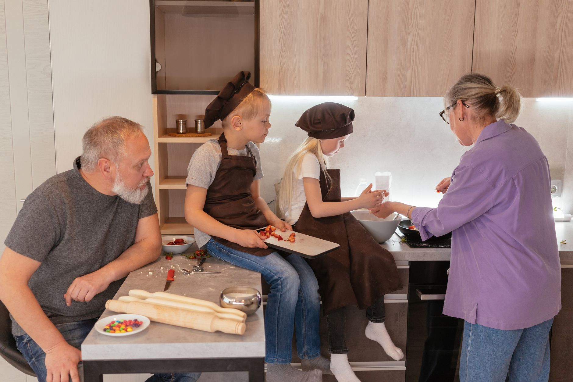 a family preparing snacks while a live JioHotStar football broadcast loads on a large living-room television