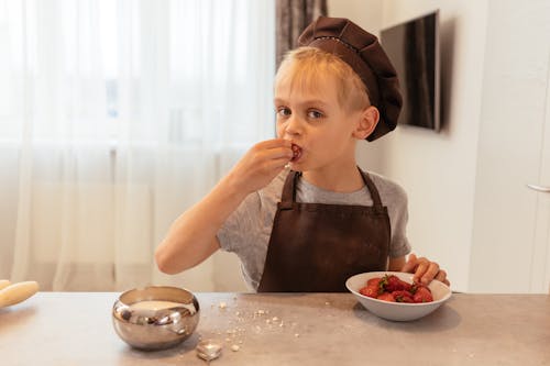 Boy in Gray Crew Neck T Shirt Eating Strawberry