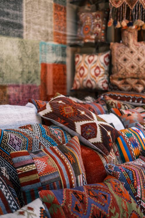 Free Vibrant array of handmade patterned pillows and textiles on display indoors. Stock Photo