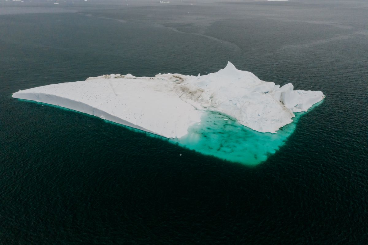 Grande massa de gelo cercada pelo oceano vista de cima