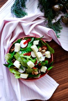 Top view of a delicious fresh cheese salad with lettuce, walnuts, and radish in Turkey.