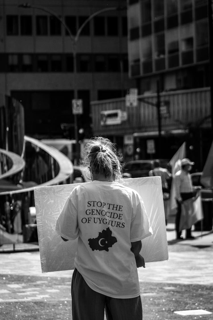 Black And White Photograph Of A Woman Protesting On Street Against Genocide Of Uyghurs