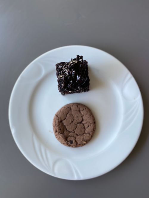 Free A close-up shot of a brownie and a cookie on a white ceramic plate, perfect for dessert lovers. Stock Photo