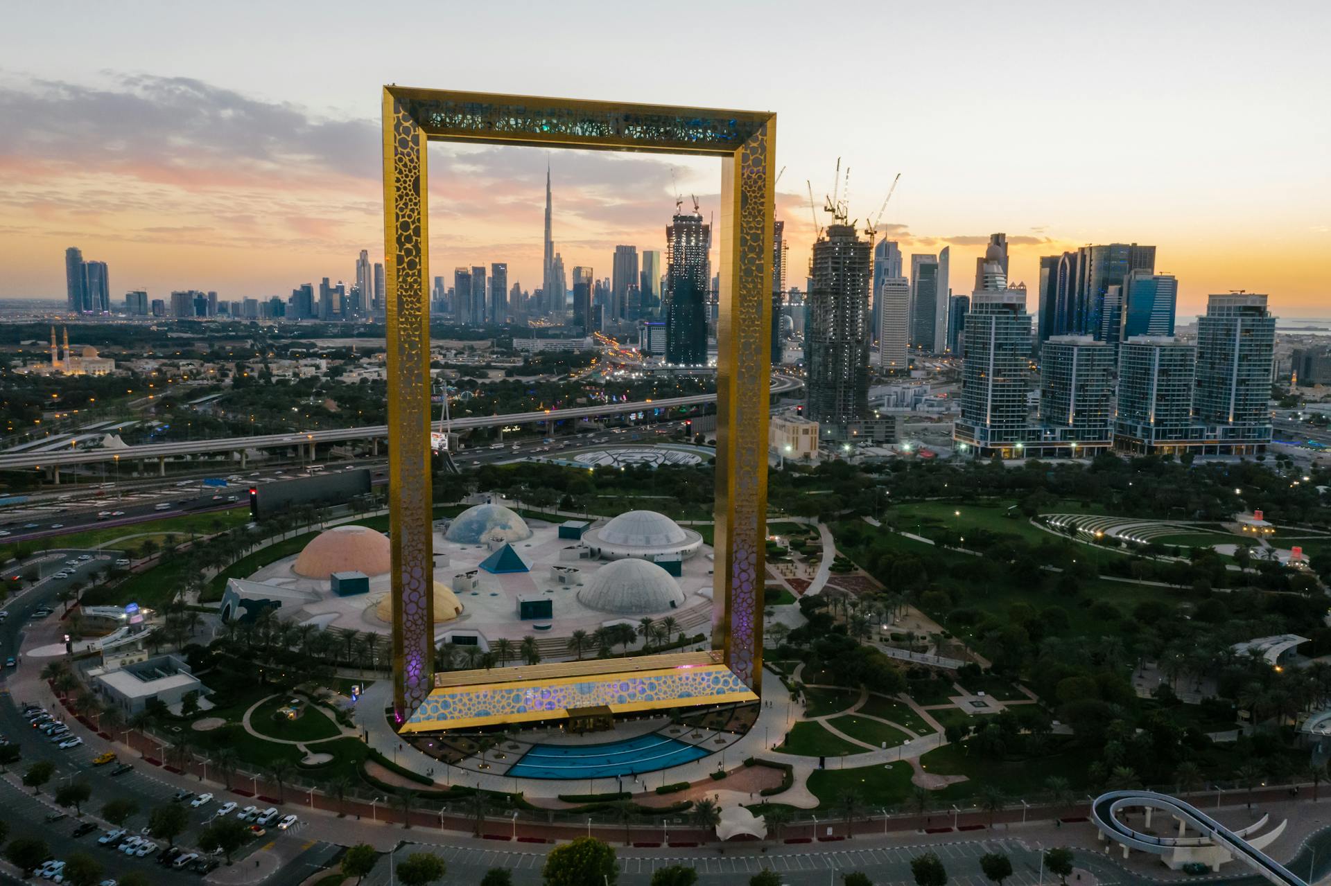 Aerial view of Dubai Frame with cityscape backdrop at sunset. Iconic landmark in UAE.