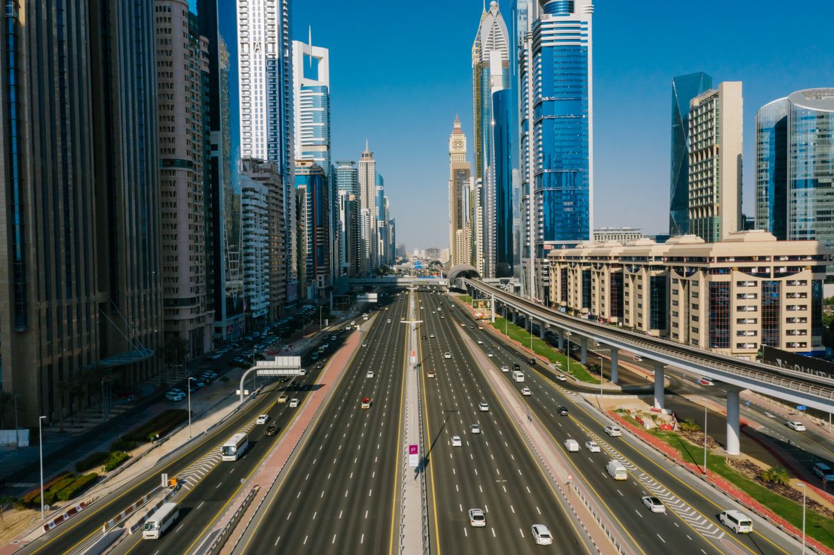 UAE rules that shape what your agent can decide Aerial view of a Dubai highway lined with skyscrapers