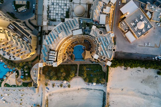 Stunning aerial view of a luxury resort hotel on a beach, showcasing intricate architecture and a scenic coastline.