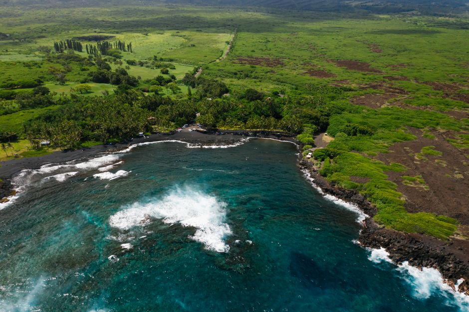 Incredible Gyroplane Flight Experience Over Kona Review: The Most Unique Way to See Hawaii's Big Island Review 2026 - A stunning aerial view of a green coastline meeting a vibrant blue ocean, showcasing natural beauty.