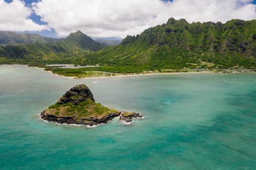 Stunning aerial view of Chinaman's Hat Island with lush green mountains and turquoise waters in Hawaii.