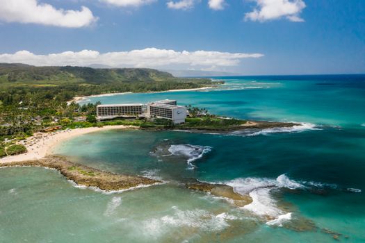 Photo by Mikhail Nilov Stunning aerial view of Turtle Bay Resort on the Hawaiian coast, showcasing the lush landscape and turquoise ocean.