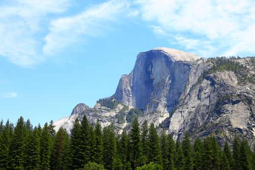 Free Majestic Half Dome in Yosemite Park with a clear blue sky and lush pine forest. Stock Photo