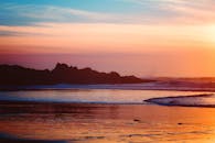 日落景色令人惊叹，五颜六色的天空与海浪映照出充满活力的色调，非常适合旅行和自然主题