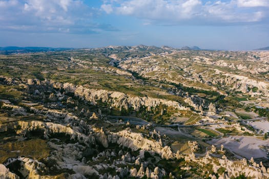 Stunning aerial view of Cappadocia's iconic rock formations under a clear blue sky.