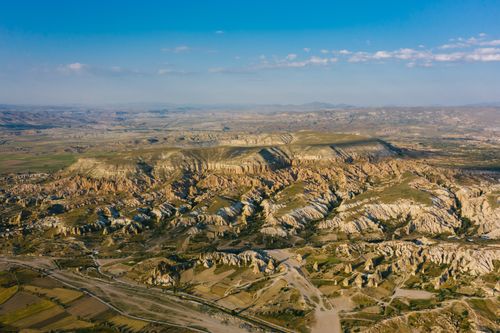 Free A stunning aerial view showcasing majestic rock formations in a vast landscape under a blue sky. Stock Photo