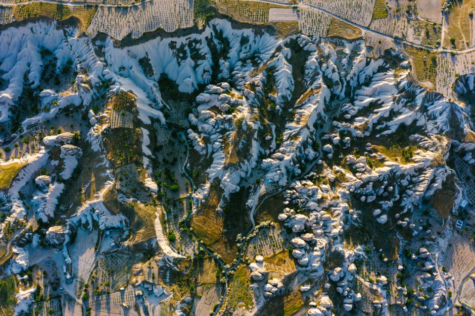A breathtaking aerial view of the unique rock formations in Cappadocia, Turkey during daylight.