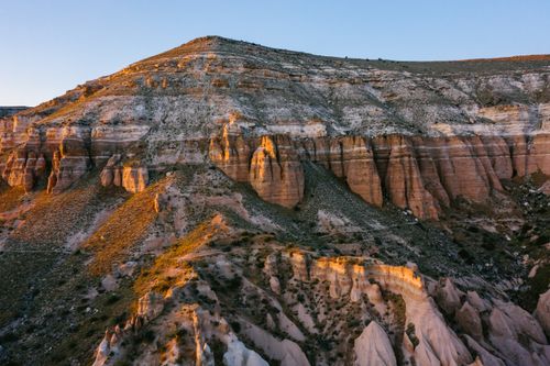 Free Aerial view of eroded rocky hill landscape at sunset, showcasing natural formations. Stock Photo