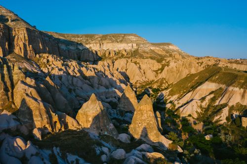Free Breathtaking panorama of Cappadocia's unique geological rock formations under a clear blue sky. Stock Photo