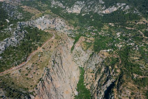 Free Stunning aerial view of a scenic mountain landscape with lush greenery and rocky cliffs. Stock Photo