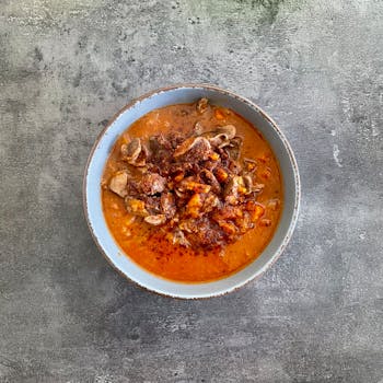 Delicious beef stew with rich spices in a bowl against rustic background.