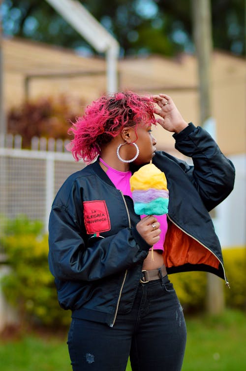 A Woman with a Pink Hair Holding a Stick of Cotton Candy