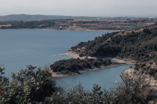 Free A breathtaking view of a coastline with lush greenery and clear blue water. Stock Photo