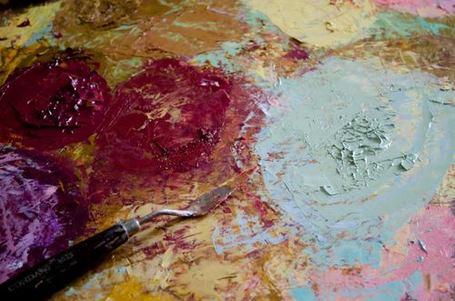 Free Vibrant close-up of paint and spatula on an artist's palette, showcasing bold textures and colors. Stock Photo
