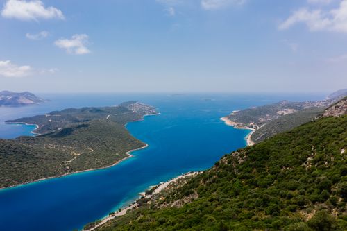 Free Stunning aerial view of a turquoise coastline and lush green islands under a bright blue sky. Stock Photo