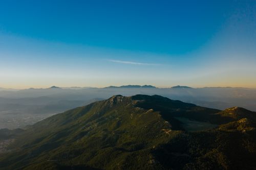 Free Stunning aerial view of a misty mountain landscape at dawn under a clear blue sky. Stock Photo