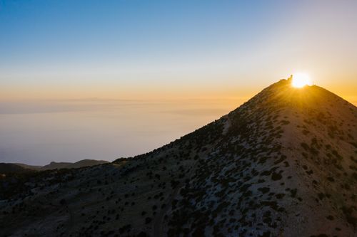 Free A breathtaking sunset over a mountain peak, capturing the golden hour with an expansive horizon view. Stock Photo