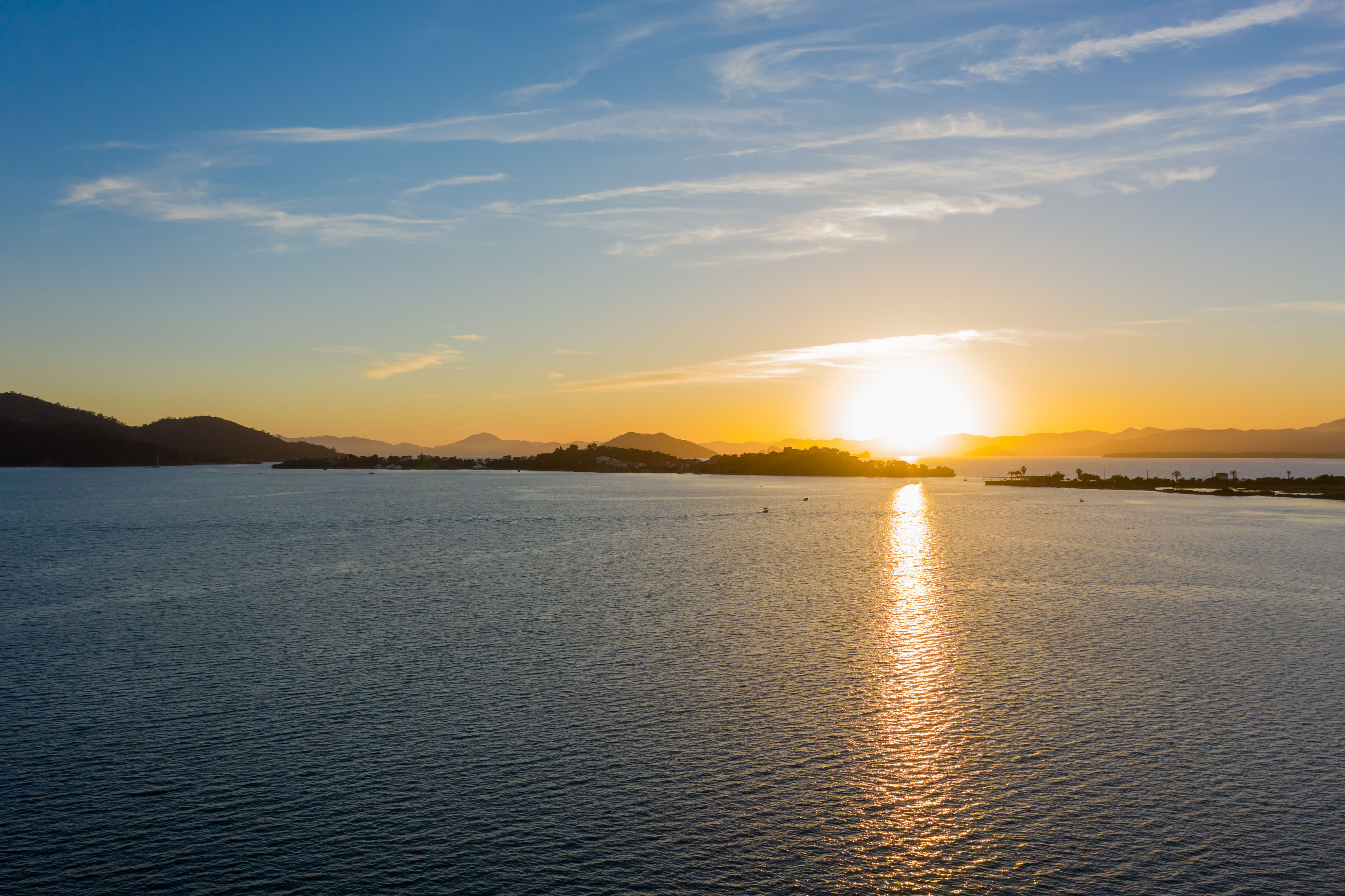 A tranquil ocean scene captured at sunset, showcasing a golden sky and serene waters