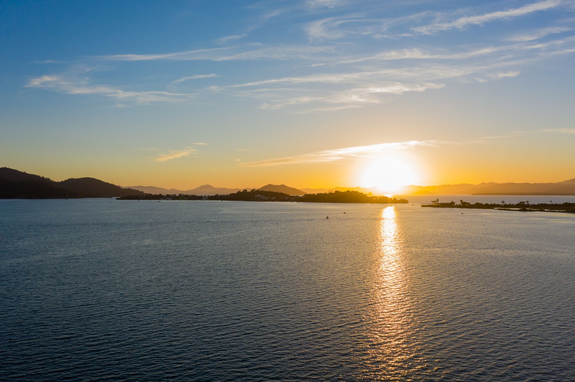 A tranquil ocean scene captured at sunset, showcasing a golden sky and serene waters