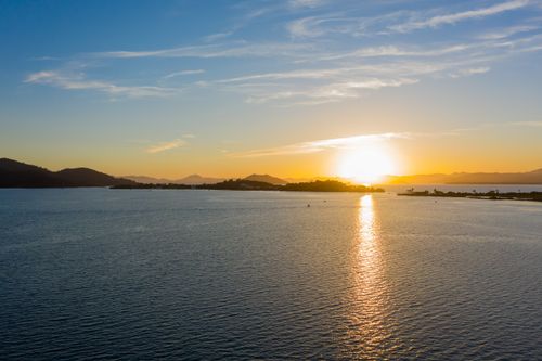 Free A tranquil ocean scene captured at sunset, showcasing a golden sky and serene waters. Stock Photo