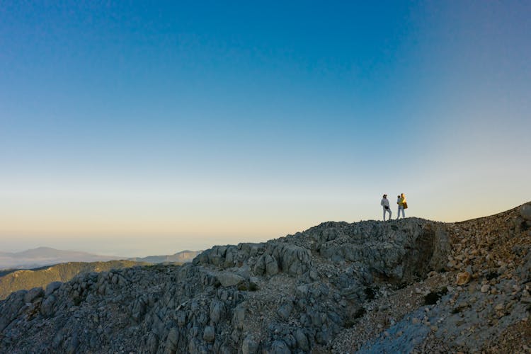 A Family Standing On The Rocky Mountain