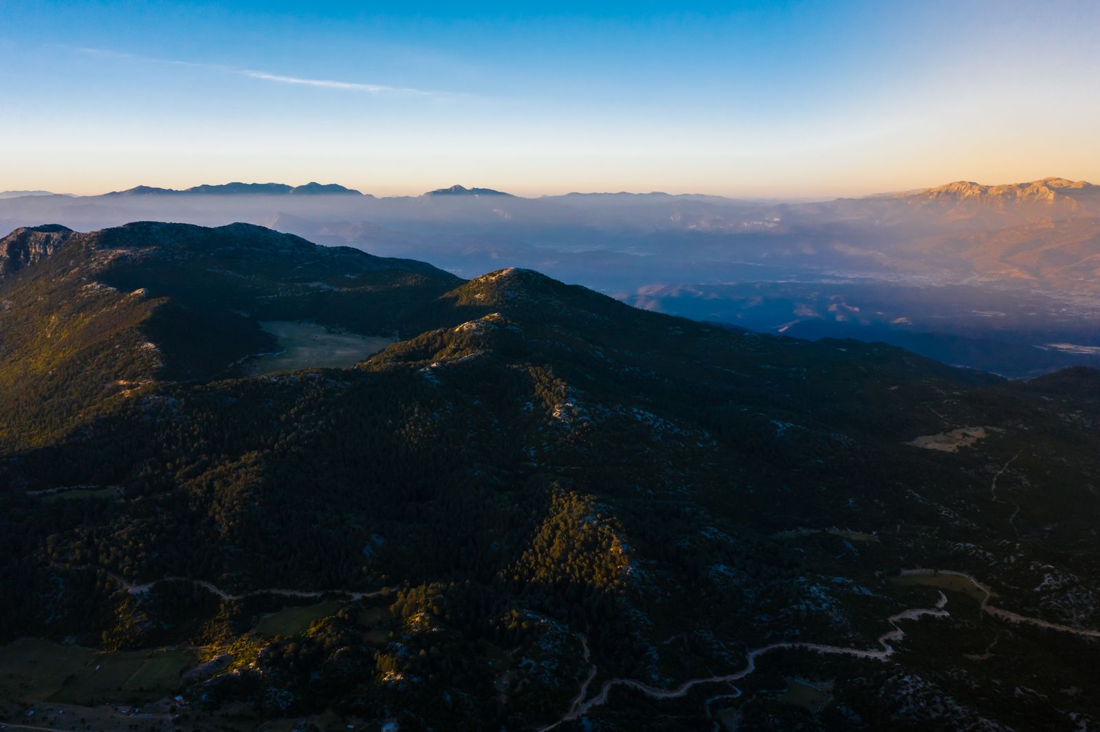 Aerial view of mountain ranges enveloped in mist at twilight — photo by Mikhail Nilov on Pexels